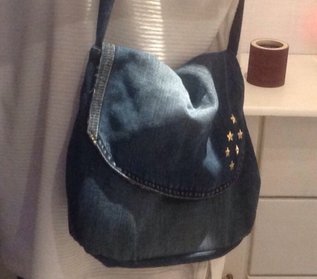 Väska av ett knä på ett par jeansbyxor